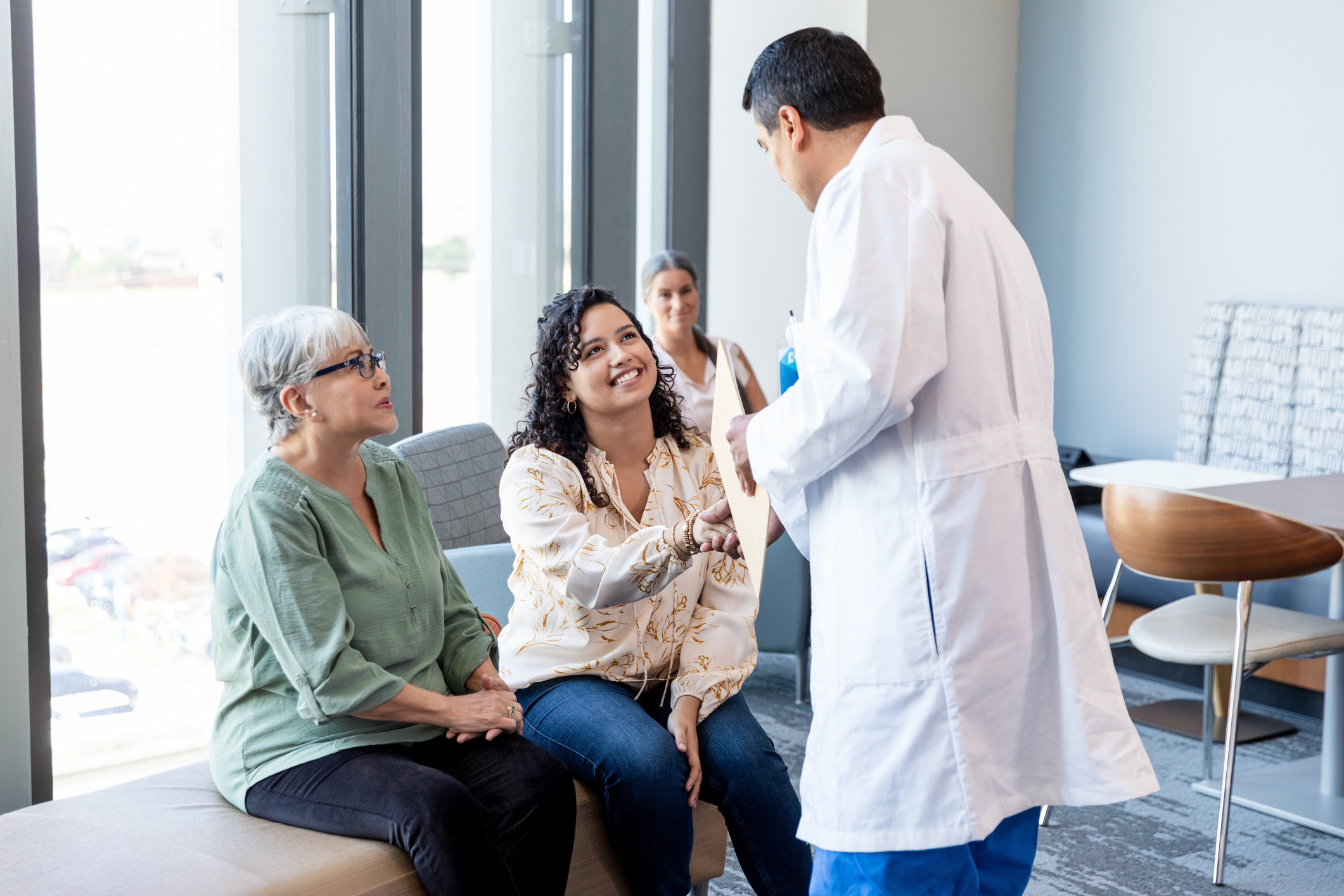 In the Er waiting room, the unrecognizable male surgeon greets the patient's  female family members.