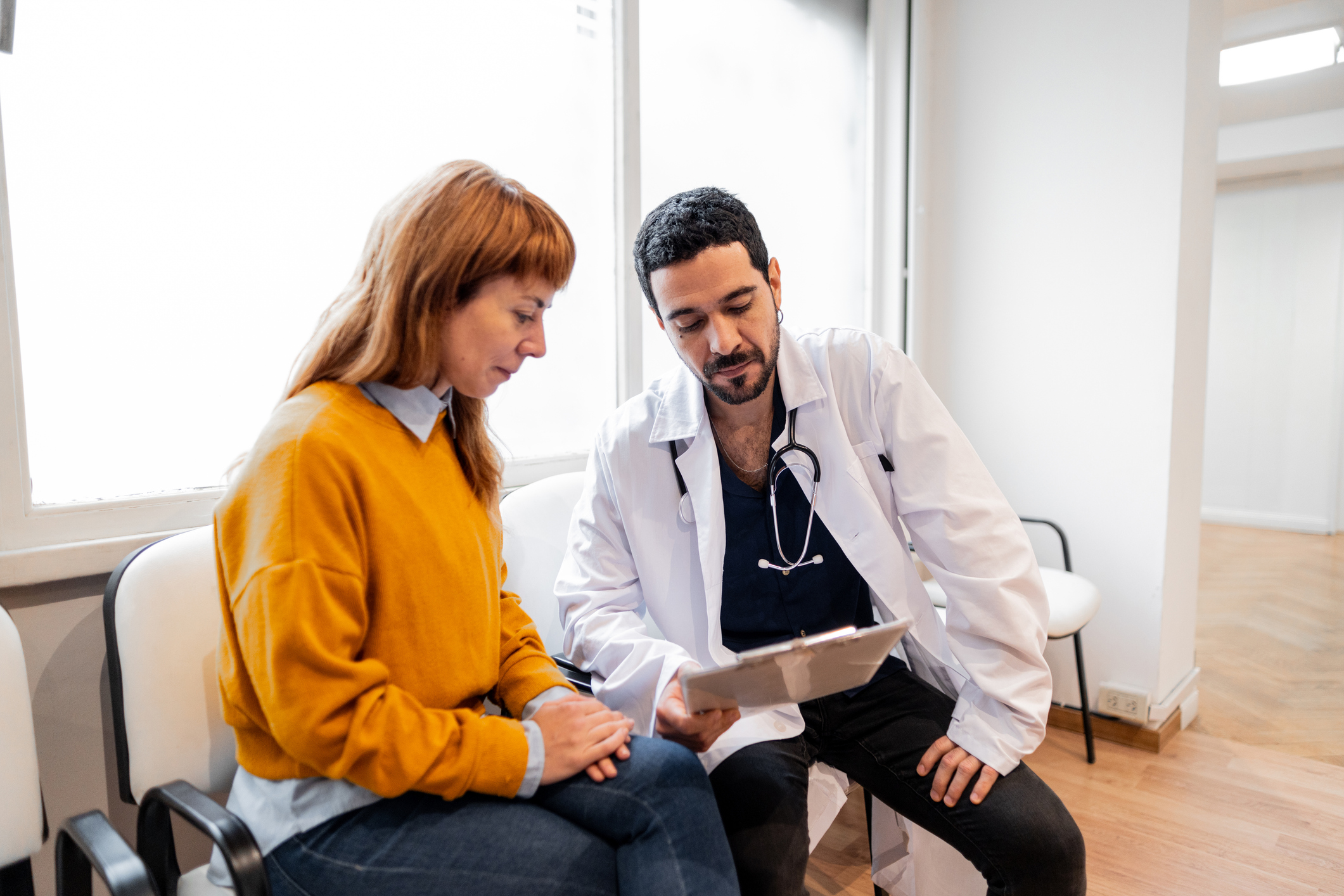 Doctor showing medical exam to patient in a hospital