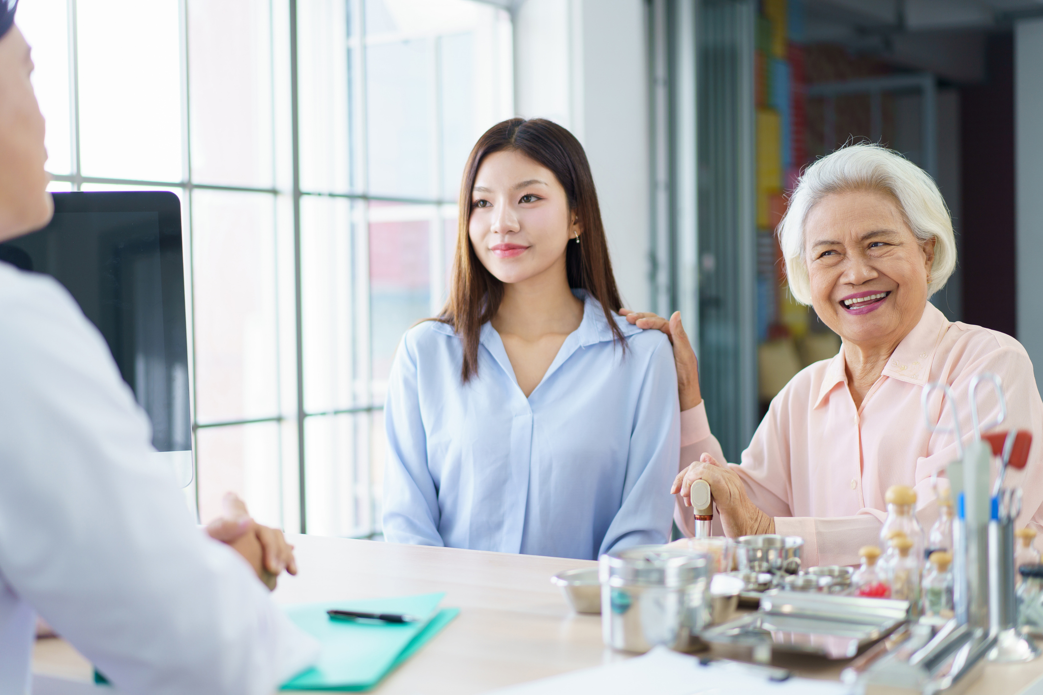 Asian young woman is taking her elderly mother to see doctor in hospital to have a medical examine. Woman take her mother visit a doctor in hospital. Wellbeing and healthcare for senior - elder people
