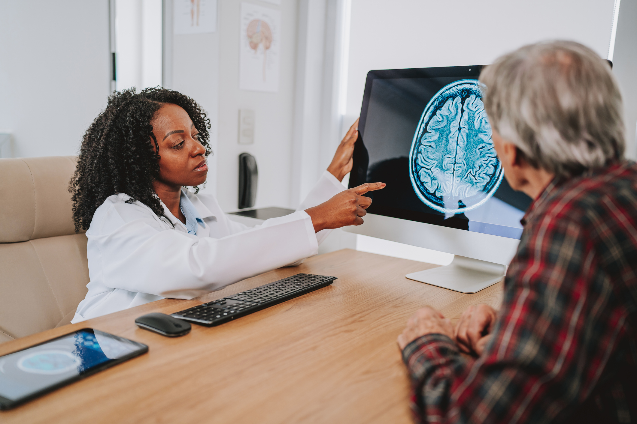 Doctor, brain CT scan, and doctor with a patient in the office for a consultation